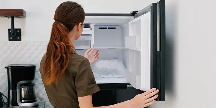 からの冷凍庫を眺める女性