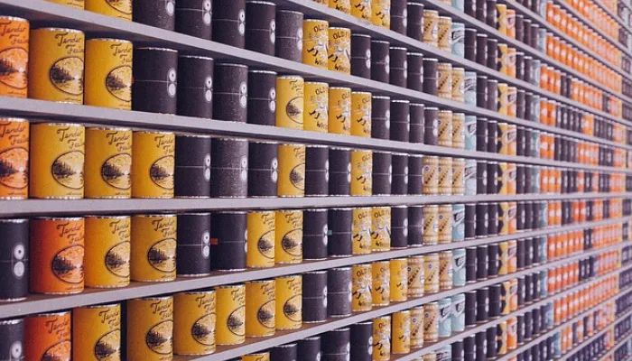 棚にびっしりと並んだ黄色、黒、オレンジの缶