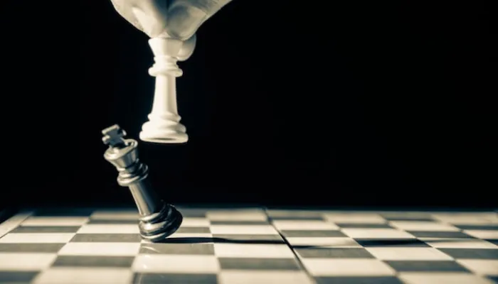 チェス盤の上で黒のキングを倒す白のキング