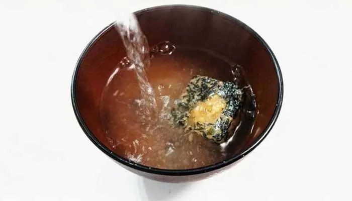 フリーズドライの味噌汁にお湯を注いでいる画像