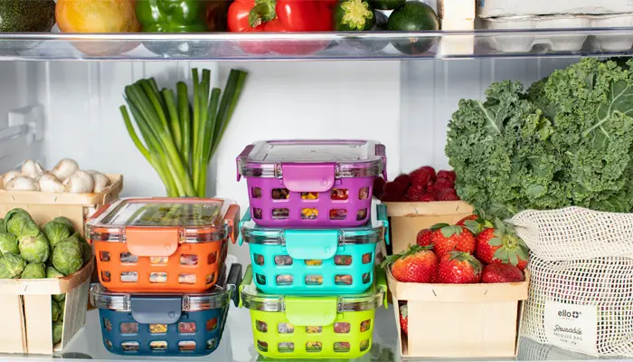 冷蔵庫に入ったカラフルなタッパーや野菜の画像