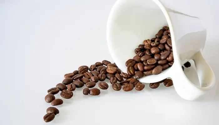マグカップから溢れるコーヒー豆