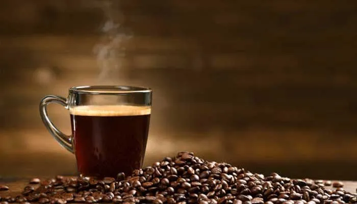 コーヒー豆の山とマグカップに入ったコーヒー