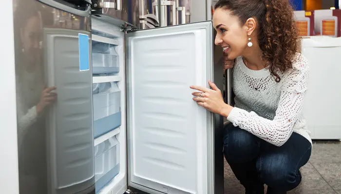笑顔の女性が冷凍庫を開けている