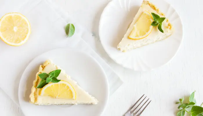 白いテーブルの上のレモンがのっているチーズケーキ2つ