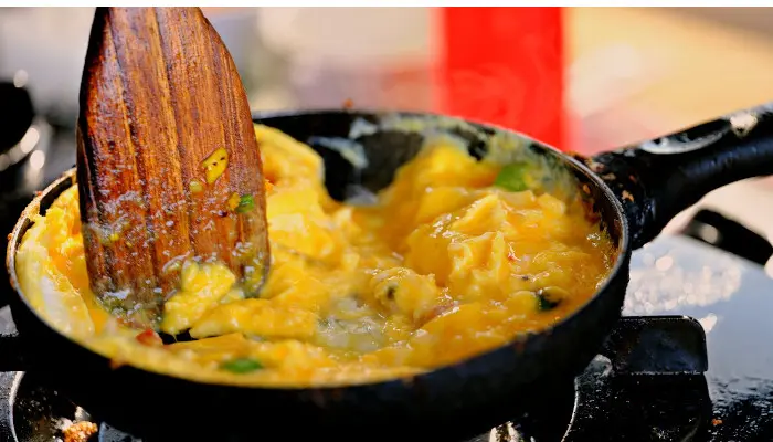 卵料理を炒めるフライパンとそれをかき混ぜるへら