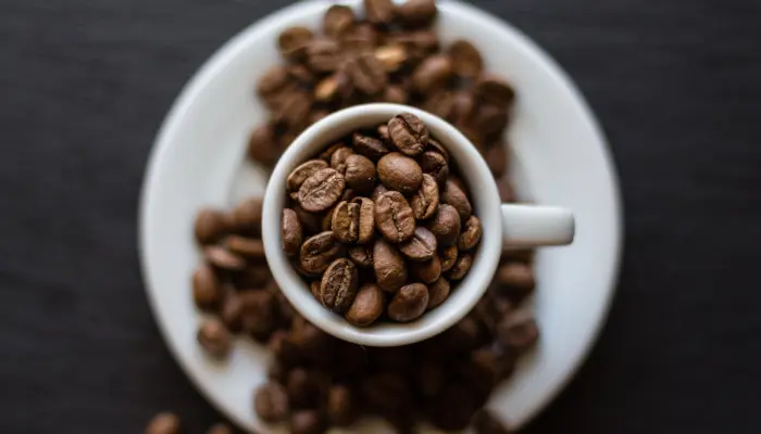 コーヒーカップからソーサーにこぼれるコーヒー豆