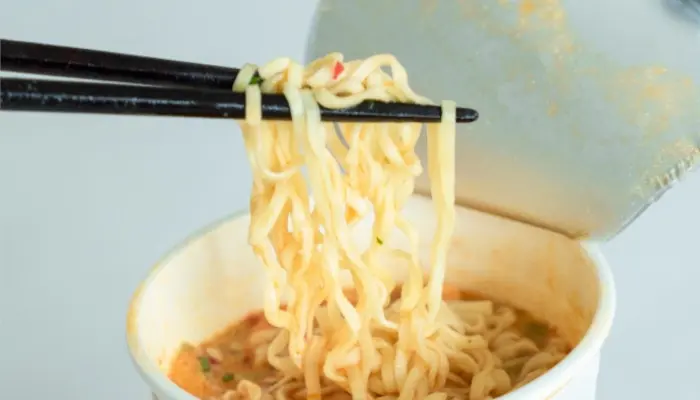 箸で一口掴まれているカップ麺